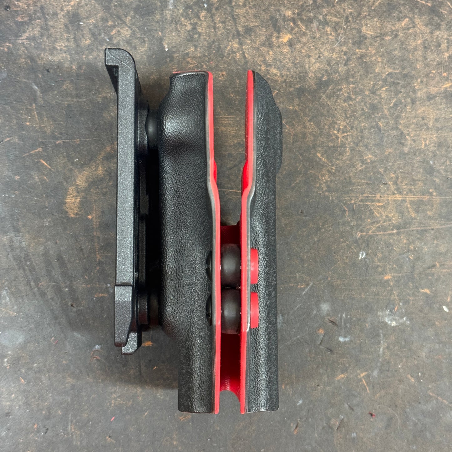 Black and red mechanical component on a textured surface