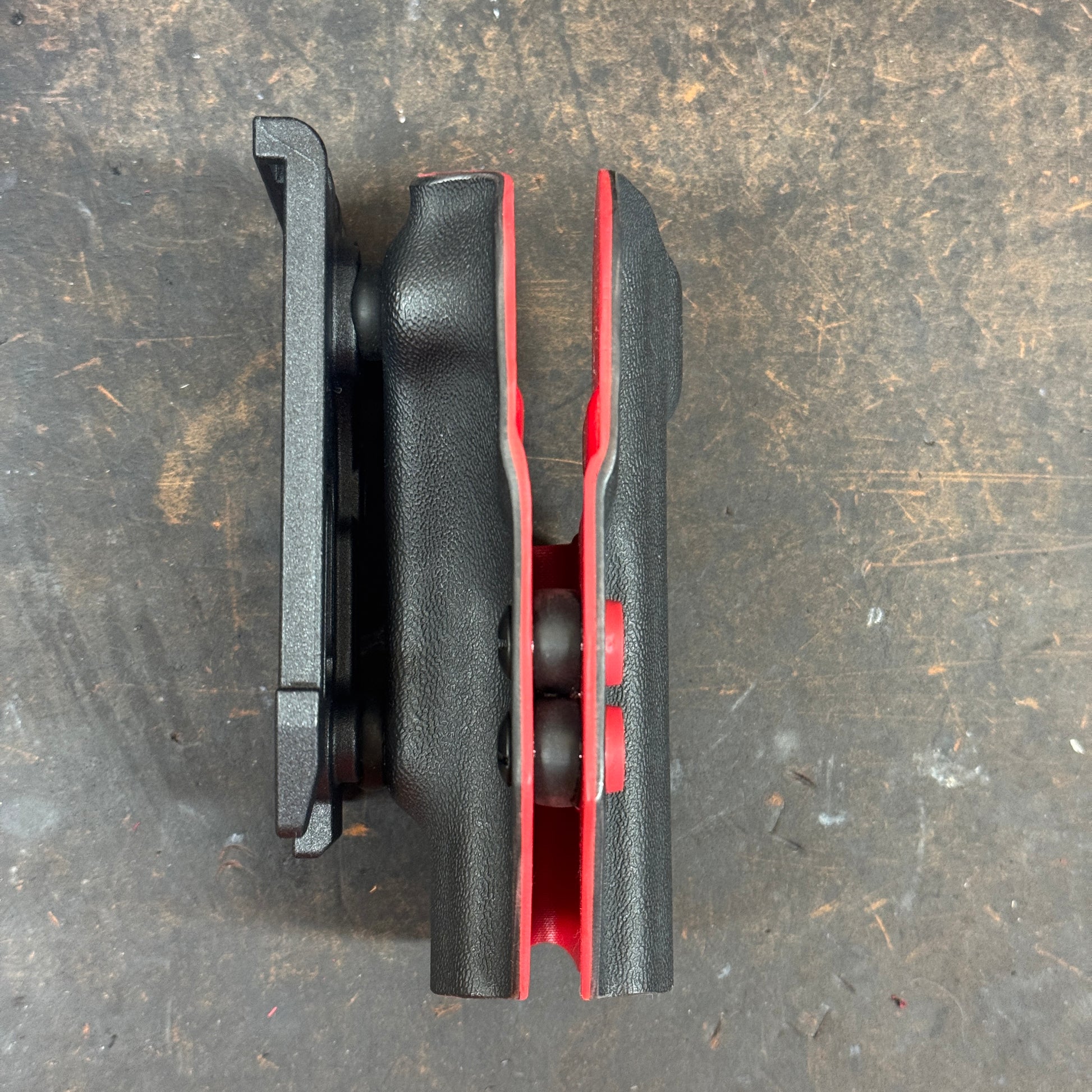 Black and red mechanical component on a textured surface